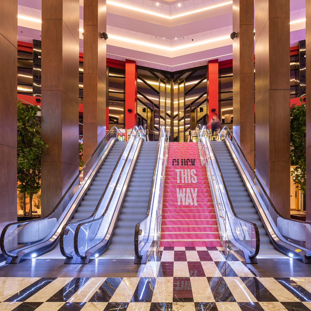 Architectural interior with escalators and warm lighting.